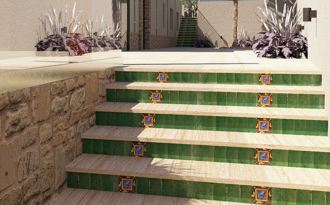 Steps clad in green hand-painted Sicilian majolica beside a natural stone wall